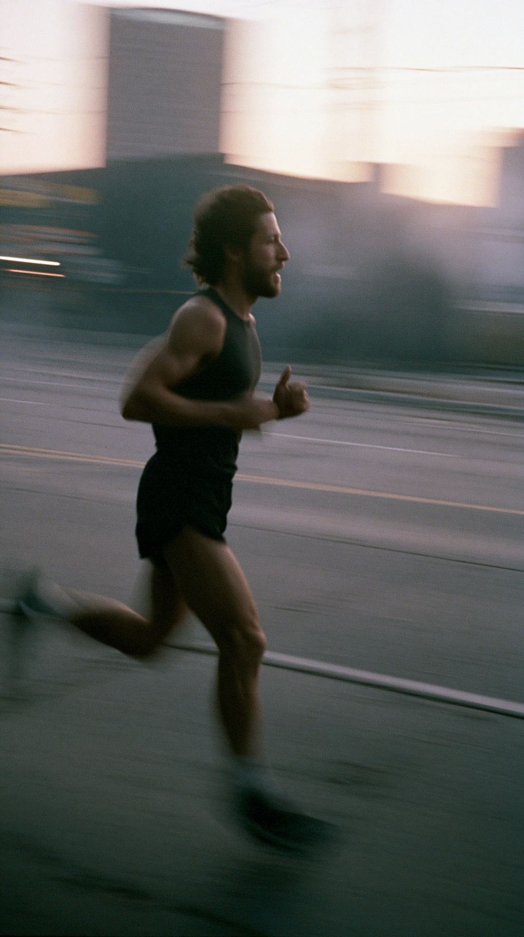 Corredor en pleno paso durante un entrenamiento al amanecer en la ciudad